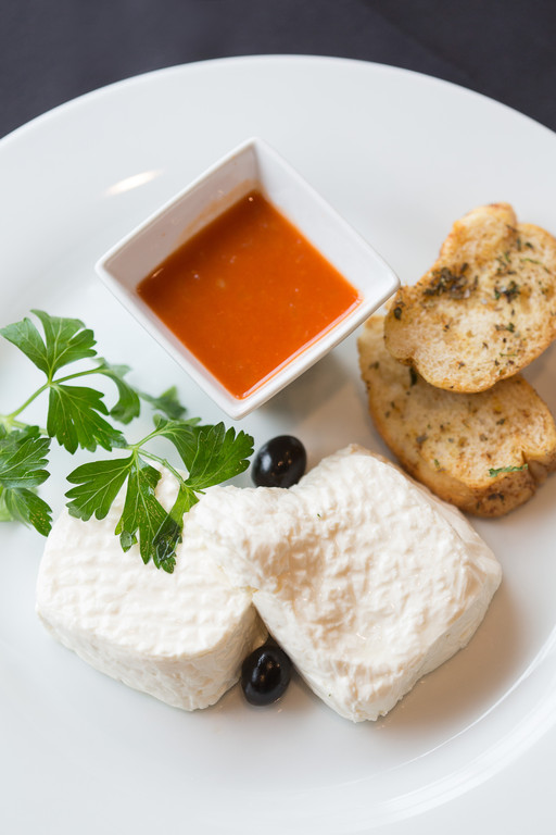 Fresh goat cheese with a freshly ground red pepper sauce and garlic toast at Caldeiras
