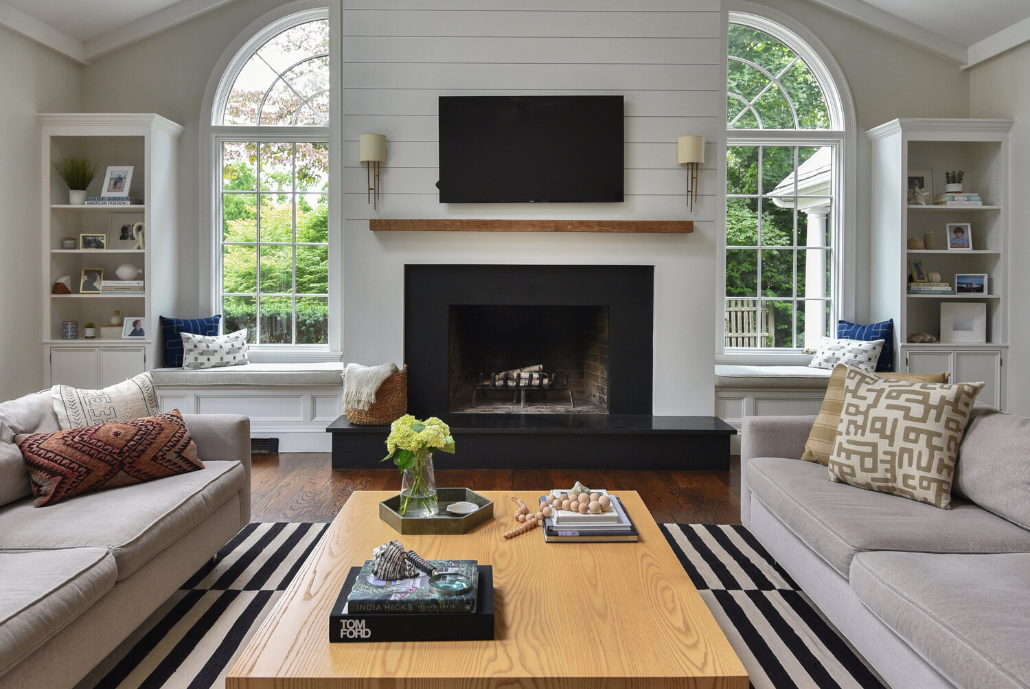 The striped area rug mirrors the shiplap above with a cosmopolitan twist
